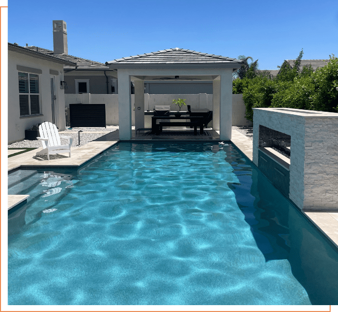 A pool with a white bench and chairs in the middle of it.